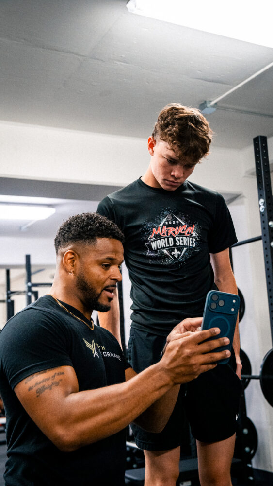 Coach showing tech to trainee for progress tracking